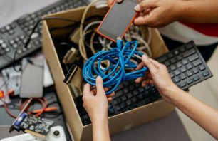 Image of asian people putting old computer parts, smartphone and cables for into cardboard box for recycling. Asian people recycling electronic waste.